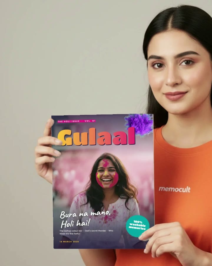 A person holds a printed photo magazine; it lifts, opens and its pages riffle, then it settles back